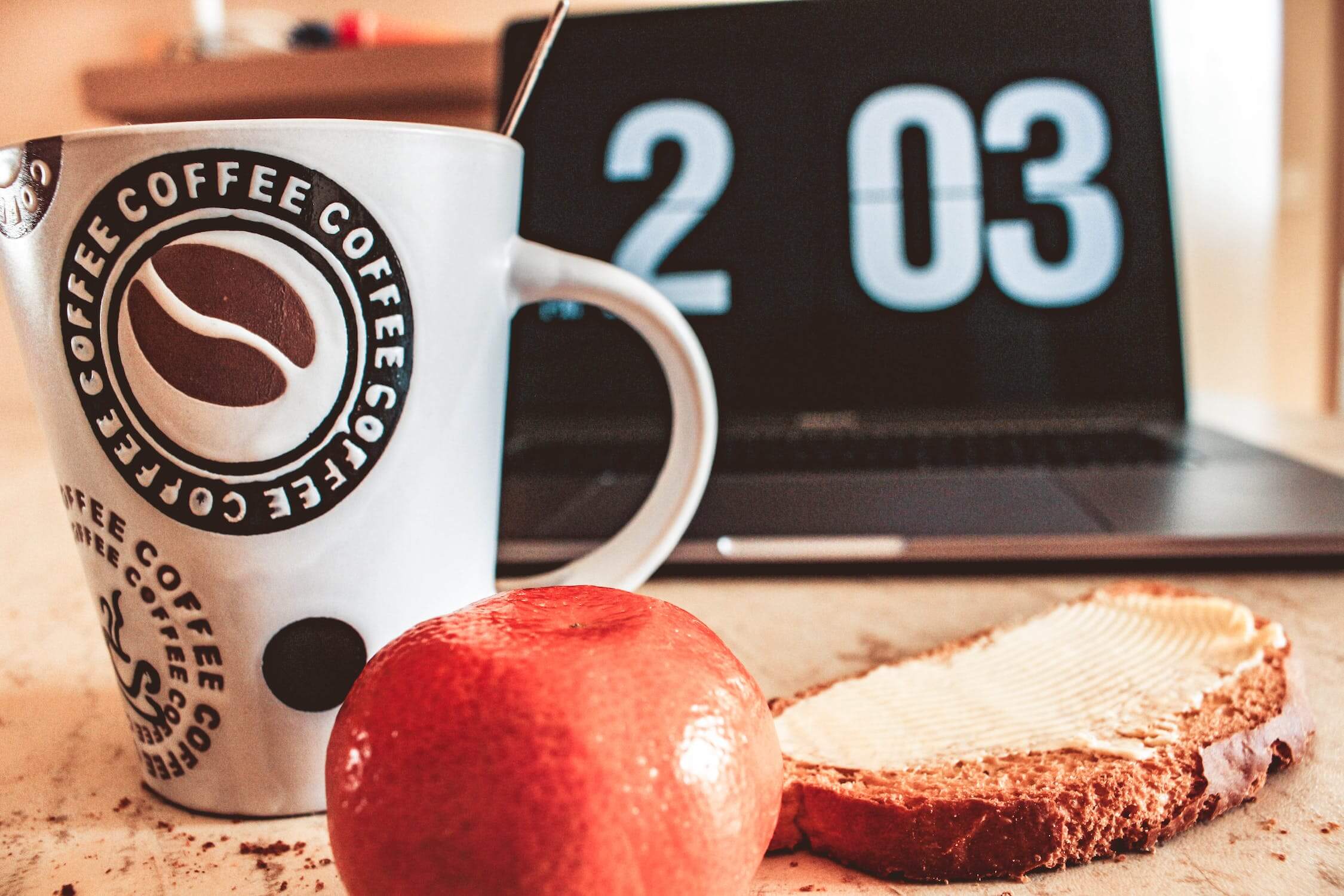 Koffie, boterham, appel en een laptop met tijd.